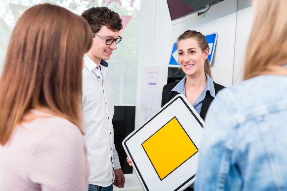 Fahrlehrerin erklärt Verkehrszeichen in einer Schulung für Fahrschüler.