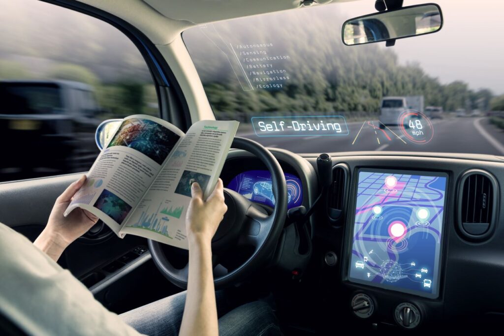 Autonomes Fahrzeug mit Fahrassistenzsystemen; Fahrer liest während der Fahrt ein Magazin, digitale Anzeigen im Cockpit sichtbar.