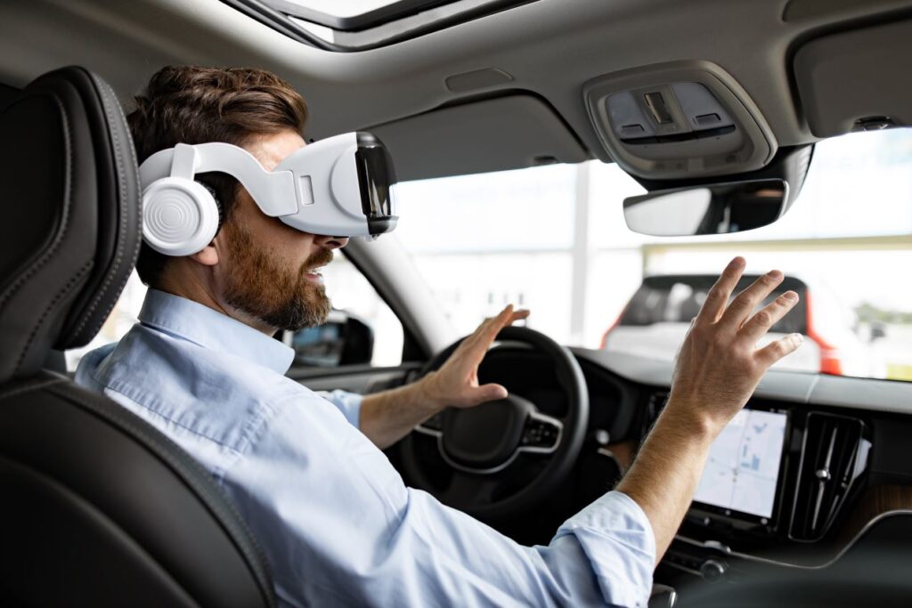 Mann mit VR-Brille simuliert Fahrsituationen in einem Fahrzeug; innovative Technik für die Ausbildung und Weiterbildung von Fahrlehrern.